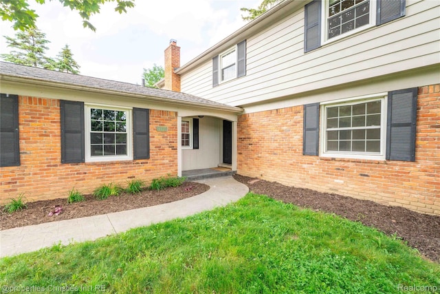 4770 Hedgewood Dr, Bloomfield Hills, MI 48301 - entrance to property featuring a chimney, brick siding, and a yard