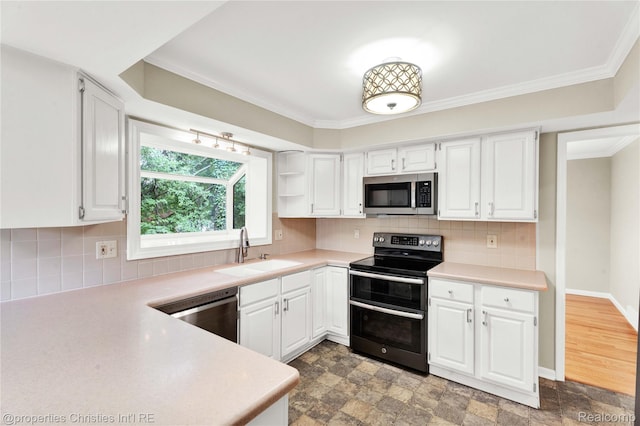 4770 Hedgewood Dr, Bloomfield Hills, MI 48301 - kitchen with stainless steel appliances, light countertops, white cabinets, and ornamental molding