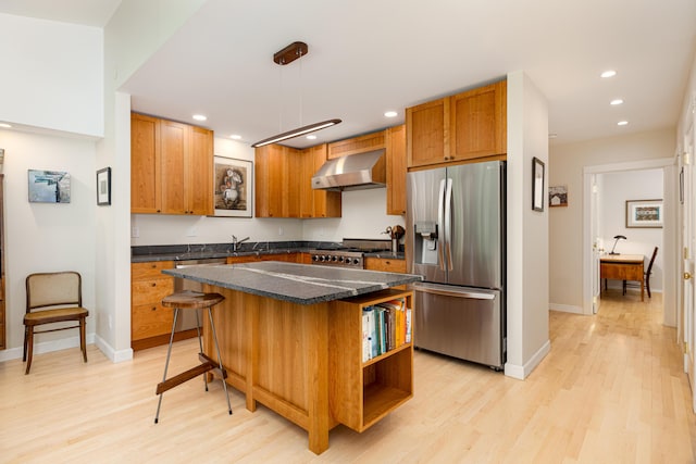 2012 Pontiac Trl, Ann Arbor, MI 48105 - kitchen with stainless steel refrigerator with ice dispenser, wall chimney exhaust hood, light wood-style flooring, recessed lighting, and a center island