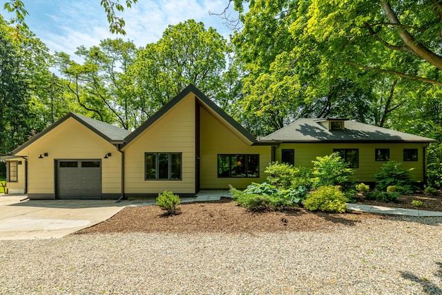 2012 Pontiac Trl, Ann Arbor, MI 48105 - view of front of home with an attached garage, driveway, and roof with shingles