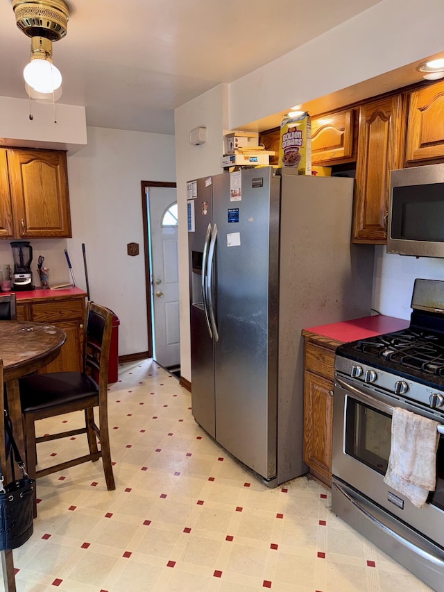 34516 John St, Wayne, MI 48184 - kitchen with appliances with stainless steel finishes, light floors, and brown cabinetry