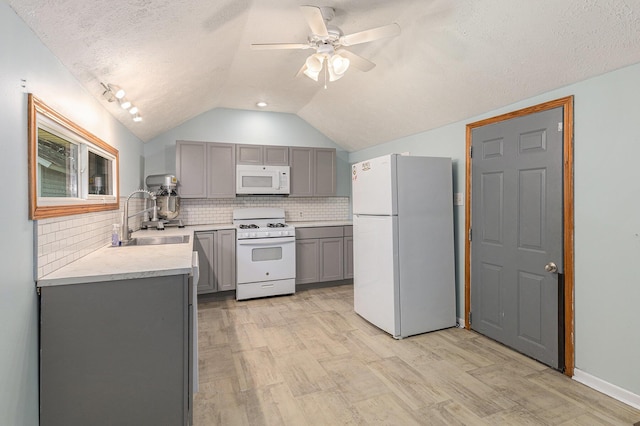 109 N Lincoln Ave, Niles, MI 49120 - kitchen featuring white appliances, gray cabinetry, lofted ceiling, light wood-style flooring, and decorative backsplash