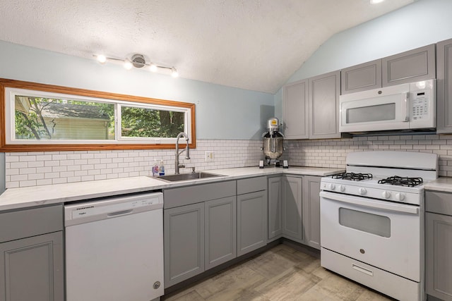 109 N Lincoln Ave, Niles, MI 49120 - kitchen featuring white appliances, gray cabinetry, vaulted ceiling, tasteful backsplash, and light countertops