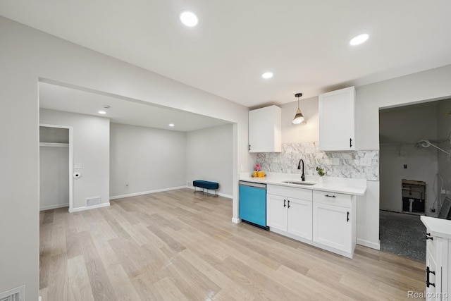 11020 Jewett Ave, Warren, MI 48089 - kitchen with dishwashing machine, light countertops, white cabinetry, decorative backsplash, and light wood finished floors