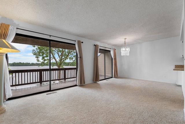 730 Cliffs Dr Unit 304A, Ypsilanti, MI 48198 - carpeted spare room featuring a chandelier, a textured ceiling, and a water view