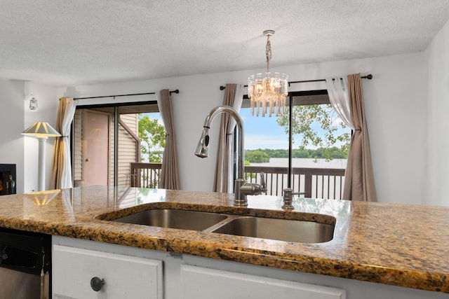 730 Cliffs Dr Unit 304A, Ypsilanti, MI 48198 - kitchen featuring a textured ceiling, dark stone counters, a chandelier, white cabinetry, and pendant lighting