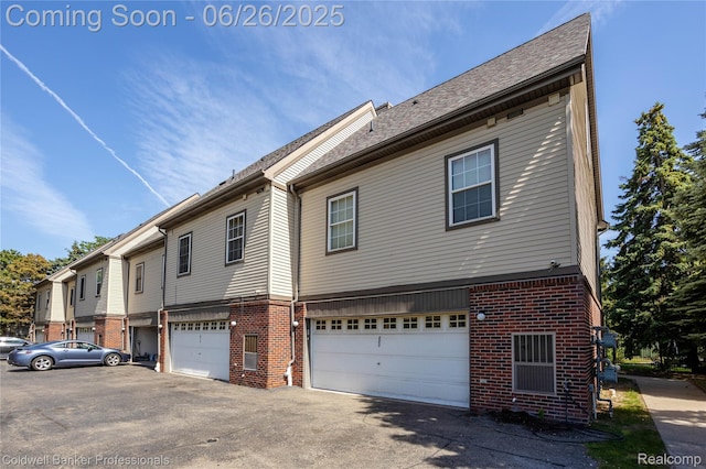 880 Seville Row, Detroit, MI 48202 - view of side of property featuring brick siding, a garage, and driveway