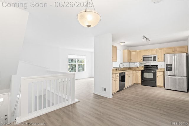 880 Seville Row, Detroit, MI 48202 - kitchen with black appliances, light brown cabinetry, light wood-style floors, open floor plan, and hanging light fixtures