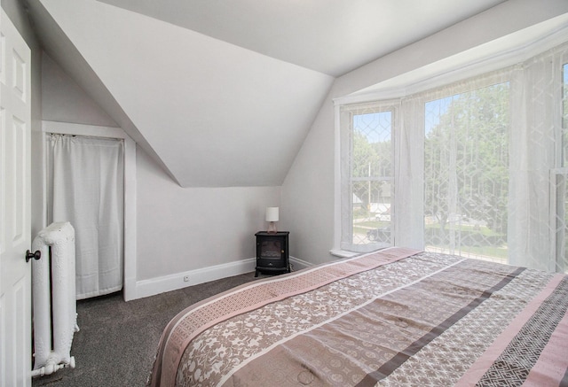 409 E Filer St, Ludington, MI 49431 - carpeted bedroom with lofted ceiling and a wood stove