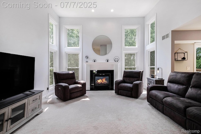 2390 Torrey Grove Ct, Fenton, MI 48430 - carpeted living area featuring a towering ceiling, plenty of natural light, a fireplace with flush hearth, and recessed lighting