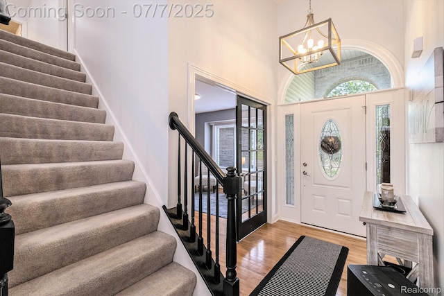 2390 Torrey Grove Ct, Fenton, MI 48430 - entrance foyer with stairs, light wood-style flooring, a chandelier, and a high ceiling