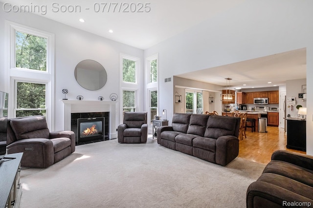 2390 Torrey Grove Ct, Fenton, MI 48430 - living room with a towering ceiling, plenty of natural light, recessed lighting, a tile fireplace, and light carpet