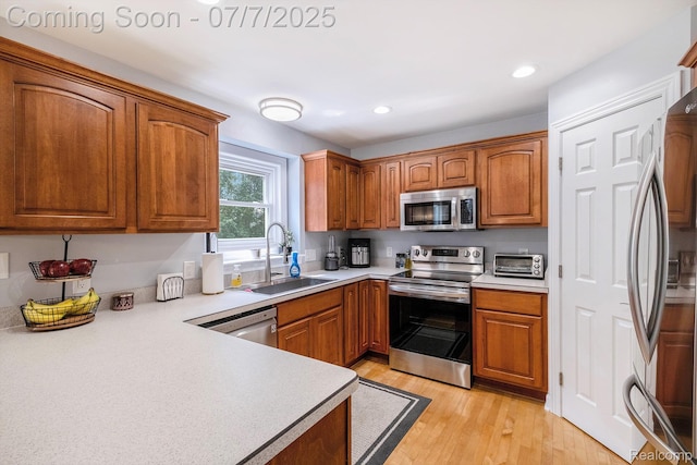 2390 Torrey Grove Ct, Fenton, MI 48430 - kitchen featuring stainless steel appliances, light countertops, brown cabinets, recessed lighting, and light wood-style flooring