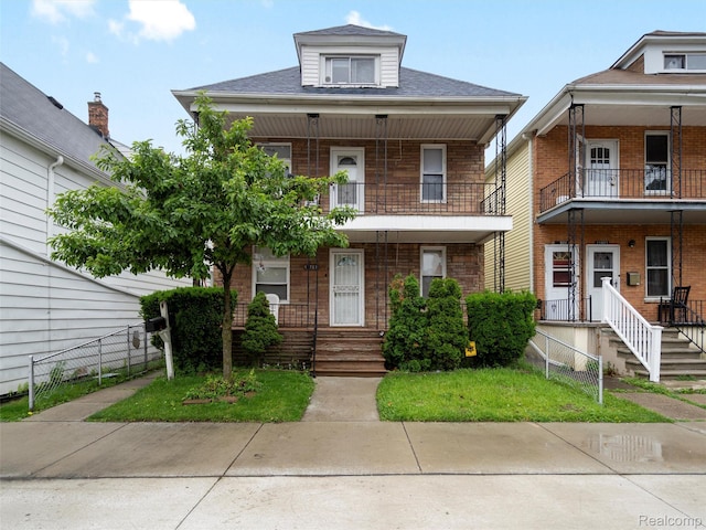 11727 Fleming St, Hamtramck, MI 48212 - view of front facade with covered porch, a balcony, brick siding, and a shingled roof