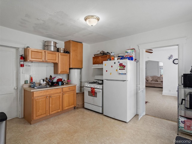 11727 Fleming St, Hamtramck, MI 48212 - kitchen with white appliances, under cabinet range hood, light countertops, water heater, and decorative backsplash
