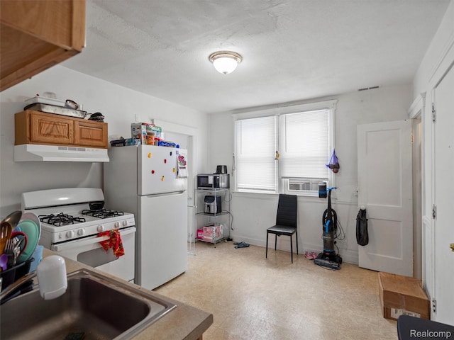 11727 Fleming St, Hamtramck, MI 48212 - kitchen with under cabinet range hood, white appliances, light flooring, brown cabinetry, and a textured ceiling