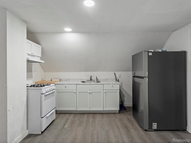 11727 Fleming St, Hamtramck, MI 48212 - kitchen with freestanding refrigerator, white gas range, under cabinet range hood, light wood-style floors, and vaulted ceiling