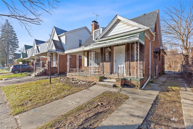 14903 Tracey St, Detroit, MI 48227 - bungalow-style house with covered porch, brick siding, a chimney, and roof with shingles
