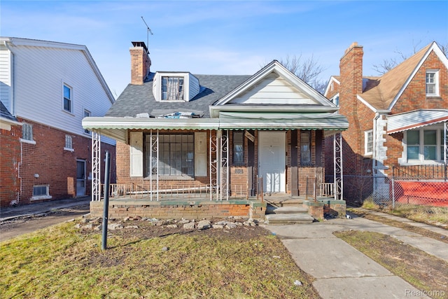 14903 Tracey St, Detroit, MI 48227 - view of front facade with covered porch, brick siding, a shingled roof, and a chimney