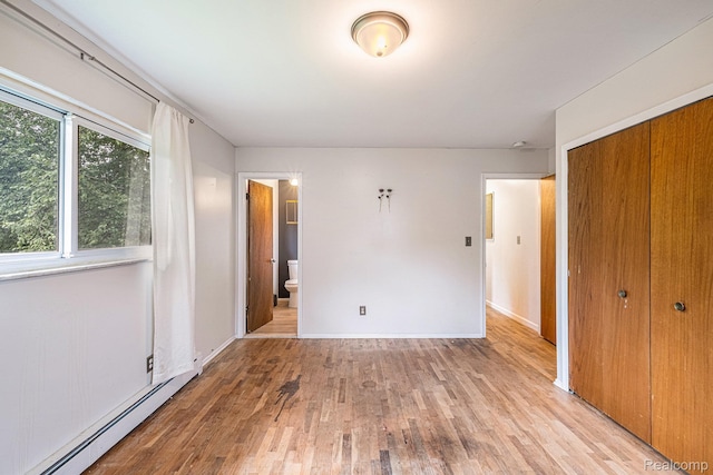 720 E Grand Blanc Rd, Grand Blanc, MI 48439 - unfurnished bedroom with a baseboard heating unit, a closet, light wood-style floors, and connected bathroom