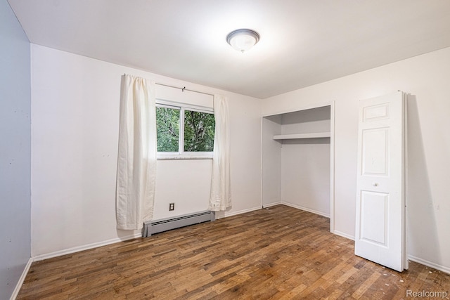 720 E Grand Blanc Rd, Grand Blanc, MI 48439 - unfurnished bedroom featuring baseboard heating, wood finished floors, and a closet