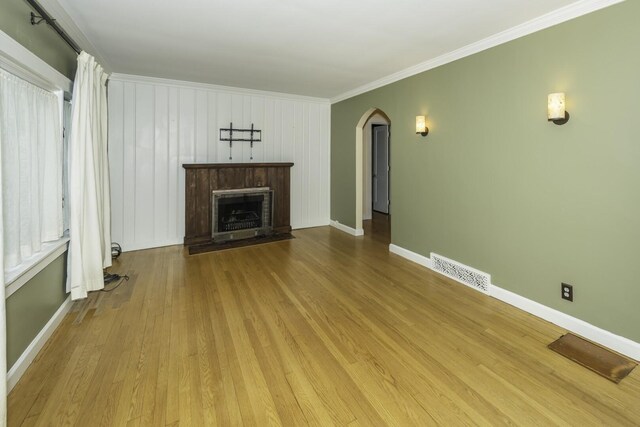 907 Pearl St, Ypsilanti, MI 48197 - unfurnished living room with arched walkways, a fireplace, wood finished floors, and crown molding