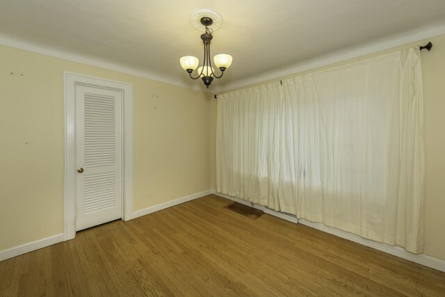 907 Pearl St, Ypsilanti, MI 48197 - unfurnished room with wood finished floors and a chandelier