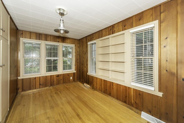 907 Pearl St, Ypsilanti, MI 48197 - spare room featuring wooden walls, wood finished floors, and built in features