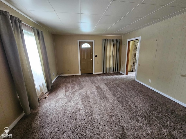 209 W Stewart St, Owosso, MI 48867 - carpeted entrance foyer featuring baseboards and wood walls