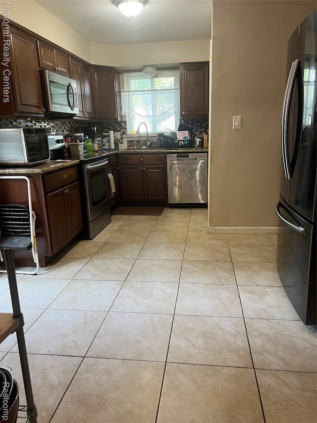 20120 N Covington Pkwy, Southfield, MI 48221 - kitchen featuring appliances with stainless steel finishes, backsplash, dark brown cabinets, and light tile patterned flooring
