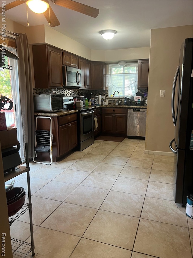 20120 N Covington Pkwy, Southfield, MI 48221 - kitchen with appliances with stainless steel finishes, tasteful backsplash, dark brown cabinetry, ceiling fan, and dark stone countertops
