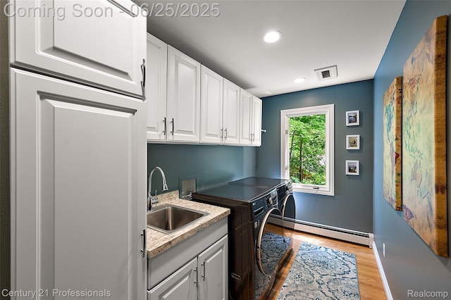 7340 Deer Lake Rd, Clarkston, MI 48346 - laundry area with a baseboard heating unit, separate washer and dryer, cabinet space, light wood finished floors, and recessed lighting