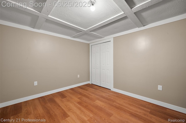 7340 Deer Lake Rd, Clarkston, MI 48346 - unfurnished bedroom with coffered ceiling, wood finished floors, a closet, beamed ceiling, and a textured ceiling