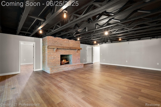 7340 Deer Lake Rd, Clarkston, MI 48346 - below grade area with wood finished floors and a brick fireplace