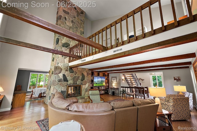 7340 Deer Lake Rd, Clarkston, MI 48346 - living room featuring stairway, wood finished floors, a fireplace, a high ceiling, and beamed ceiling