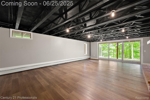 7340 Deer Lake Rd, Clarkston, MI 48346 - below grade area featuring a baseboard heating unit and wood finished floors