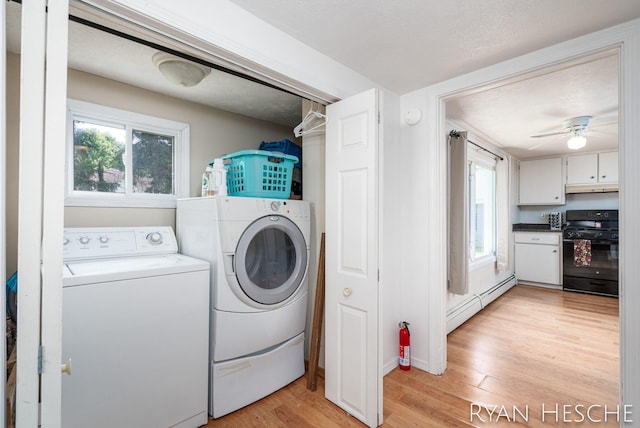 160 Division St, Saranac, MI 48881 - laundry room featuring a baseboard heating unit, washer and dryer, light wood-type flooring, and healthy amount of natural light