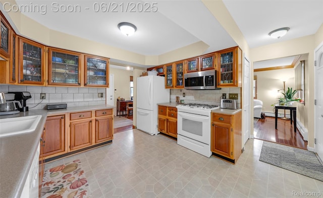 47645 Sugarbush Rd, Chesterfield, MI 48047 - kitchen with white appliances, tasteful backsplash, light countertops, glass insert cabinets, and brown cabinets