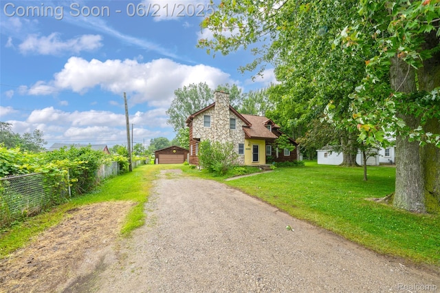47645 Sugarbush Rd, Chesterfield, MI 48047 - view of front of house featuring a chimney, an outbuilding, driveway, a detached garage, and stone siding
