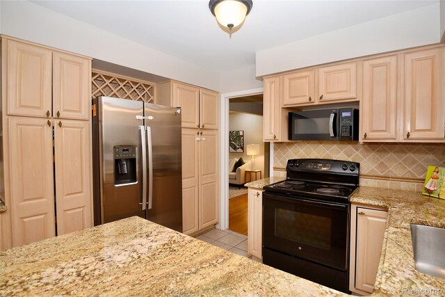 6835 Limerick Ln, Troy, MI 48098 - kitchen with black appliances, light tile patterned flooring, light stone counters, decorative backsplash, and cream cabinets