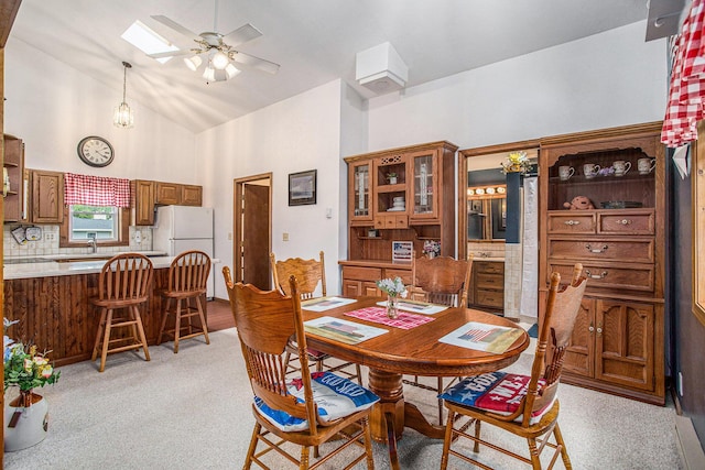 8150 B Dr N, Battle Creek, MI 49014 - dining area with a skylight, ceiling fan, high vaulted ceiling, and light carpet