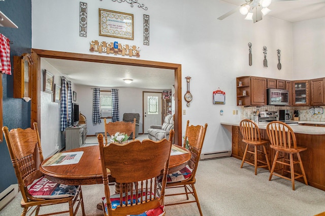 8150 B Dr N, Battle Creek, MI 49014 - dining room featuring light colored carpet, baseboard heating, a baseboard radiator, and a ceiling fan