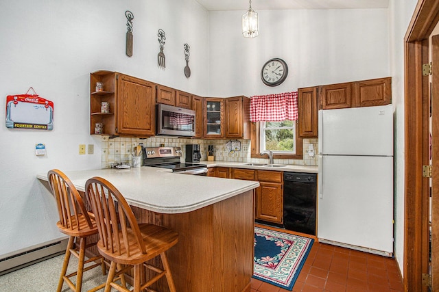 8150 B Dr N, Battle Creek, MI 49014 - kitchen with appliances with stainless steel finishes, brown cabinetry, a peninsula, light countertops, and a high ceiling