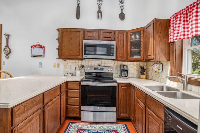 8150 B Dr N, Battle Creek, MI 49014 - kitchen with appliances with stainless steel finishes, decorative backsplash, light countertops, and a peninsula