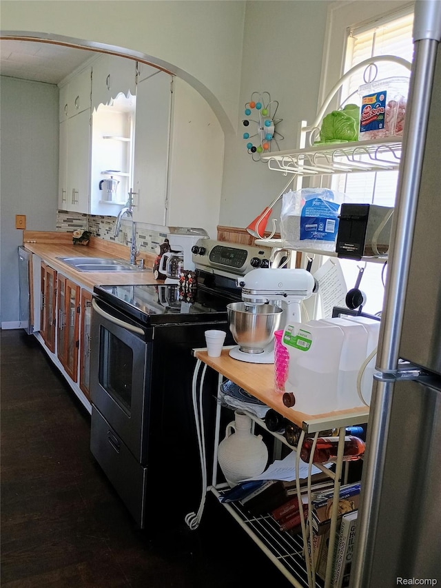 1460 S Dye Rd, Flint, MI 48532 - kitchen with stainless steel appliances, white cabinetry, and arched walkways