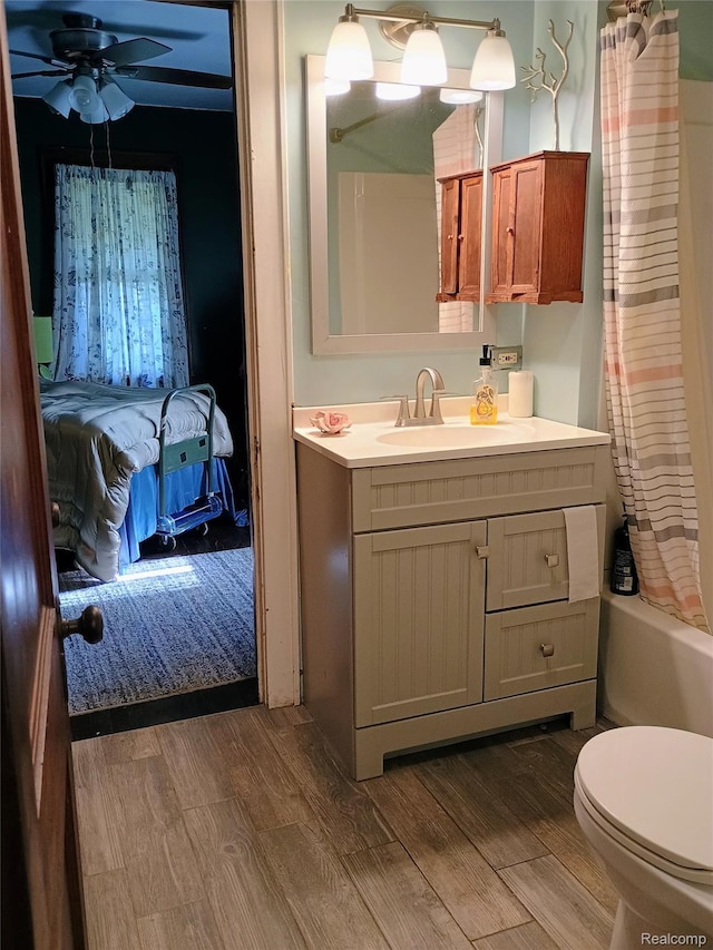 1460 S Dye Rd, Flint, MI 48532 - bathroom featuring wood finished floors, vanity, ceiling fan, and shower / bathtub combination with curtain