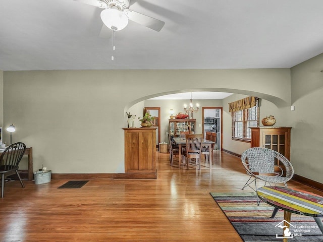 2252 W Temperance Rd, Temperance, MI 48182 - living room featuring arched walkways, light wood finished floors, ceiling fan, and a chandelier
