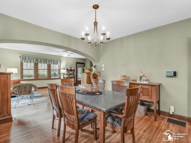 2252 W Temperance Rd, Temperance, MI 48182 - dining space with arched walkways, light wood-style flooring, a chandelier, and ceiling fan