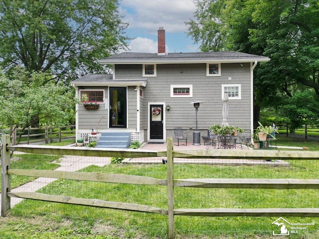 2252 W Temperance Rd, Temperance, MI 48182 - rear view of house featuring a chimney, a fenced front yard, and roof with shingles