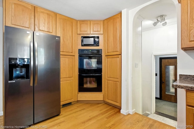 42424 Bradner Ct, Plymouth, MI 48170 - kitchen featuring black appliances, light wood-type flooring, arched walkways, and dark countertops